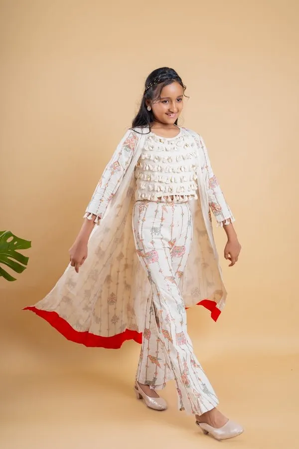 Vibrant ivory ensemble with colorful prints and tassel accents, perfect for a chic and playful look at any festive occasion.